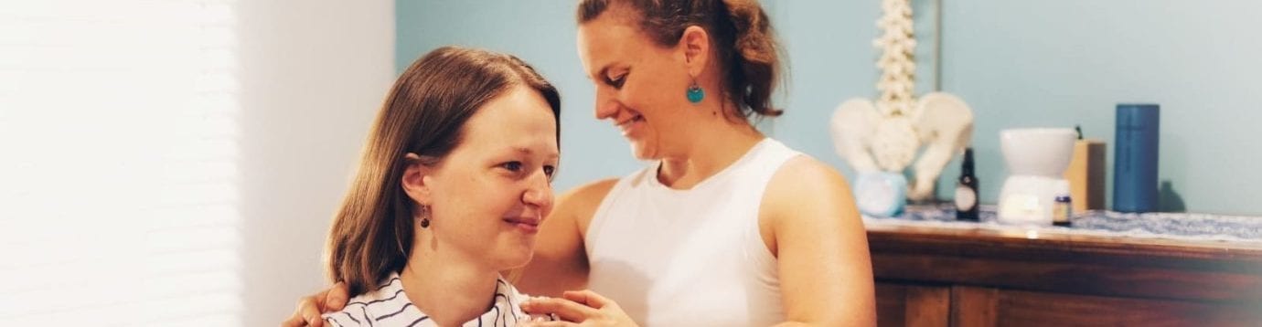 Physiotherapist Cat Meunier examining a clients shoulders